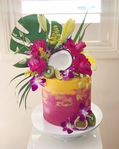 a colorful cake decorated with flowers and fruit