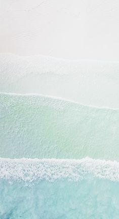 two surfers are riding the waves on their surfboards in the blue green water