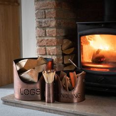 a wood burning stove sitting next to a pile of logs