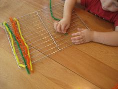 a young boy is playing with some sort of toy on the floor in front of him