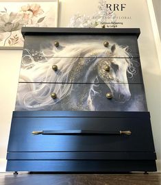 a blue dresser with a white horse painted on it