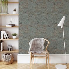 a chair in front of a bookshelf with a lamp on top of it