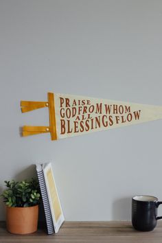 a wooden sign with words on it sitting next to a potted plant and book