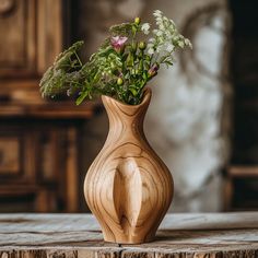 a wooden vase filled with flowers on top of a table