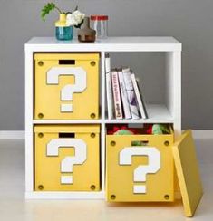 a white book shelf with yellow bins and question marks on it