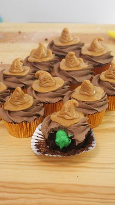 cupcakes with chocolate frosting and witches hats on them sitting on a table