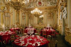 a fancy dining room with red tablecloths and chandeliers