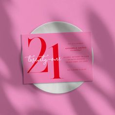 a pink and white plate with the number twenty one on it next to a pink background