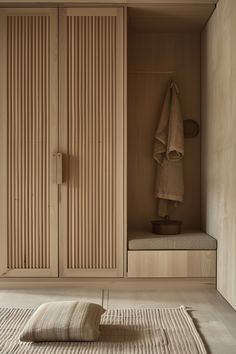 an empty room with wooden closets and towels on the floor