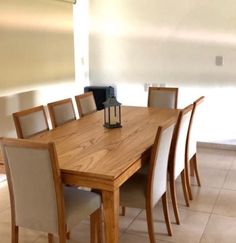 a wooden table with chairs around it and a lantern on the top of one end