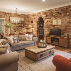 a living room filled with furniture and a brick wall