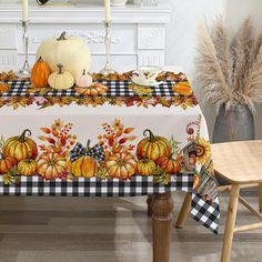 a table topped with a black and white checkered table cloth covered in pumpkins