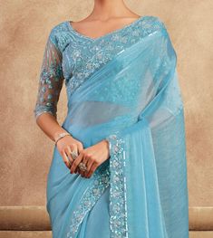 COLOR : Sky Blue FABRIC : Saree - Chiffon Silk, Blouse - Chiffon Silk & Net WORK : Resham Embroidery, Stones, Sequins, Lace BorderOCCASION : Wedding, Engagement, Party Wear, Festival, Sangeet NOTE : The outfit includes blouse and saree only. Petticoat is not included. READY-TO-WEAR : No STITCHING : Available as semi-stitched fabric, can be stitched using standard size option (+$30). Note: There might be a slight color variation due to lighting and flash used during photoshoot. The bright shade s Blue Blouse For Eid Reception, Blue Elegant Blouse For Eid, Blue Blouse With Dupatta For Festive Occasions, Blue Dupatta Blouse For Eid, Blue Blouse With Dupatta For Eid, Party Blouse Piece With Intricate Blue Embroidery, Blue Blouse With Sheer Dupatta, Formal Blue Saree, Fitted Blue Blouse Piece With Intricate Embroidery