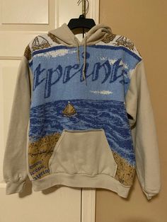 a sweatshirt hanging on a door with the words hippie 101 printed on it and an image of a sailboat in the ocean