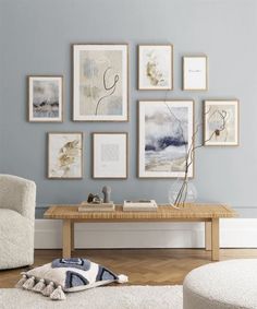 a living room with blue walls and pictures on the wall above the coffee table in front of it