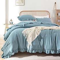 a bed with blue sheets and pillows in a room