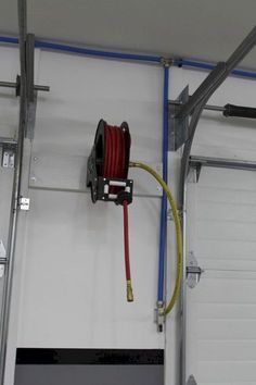 a red hose connected to the side of a garage door