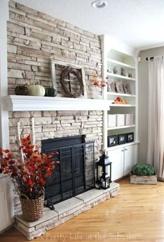 a living room filled with furniture and a fire place in front of a brick wall