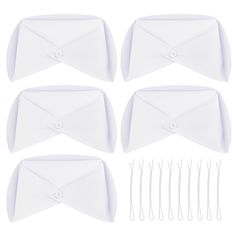 six pieces of white paper with hair clips