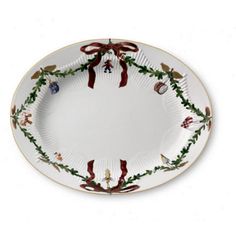 a white plate with red bows and holly decorations on the rim, decorated with ribbon