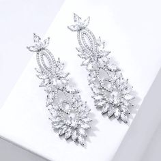 A delightfully unique pair of wedding earrings for the unconventional bride! The flawlessly faceted cubic zirconia stones capture the light in a dazzling array of sparkles, while the delicate links add fluidity and motion. The earrings are rhodium plated for a bright finish which enhances the intricate detailing and conveys a modern take on old elegance. Length: 2.5" (approx. 6.3cm); Width: 0.8" (approx. 2.2cm); Weight: 17g. Hypoallergenic - lead, nickel and cadmium free. This exquisite design w Cubic Zirconia Bridal Earrings, Unconventional Bride, Silver Wedding Jewelry, Wedding Earrings, Bridal Earrings, Exquisite Design, Future Wedding, Rhodium Plated, Wedding Jewelry