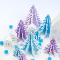 some paper trees and houses on a white surface