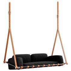 a black couch sitting on top of a wooden frame swing bed next to a white wall