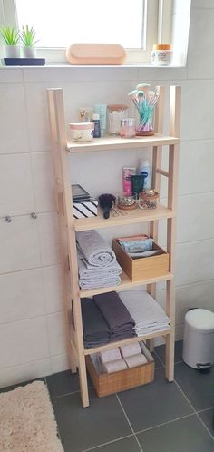 a shelf in the corner of a bathroom with towels and other items on top of it