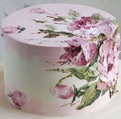 a white cake with pink flowers painted on it