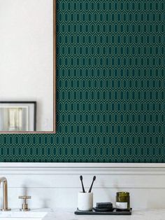 a bathroom with green wallpaper and white counter tops, two faucets and a mirror on the wall