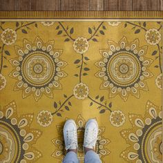 a person standing in front of a yellow rug