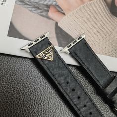 Premium Leather Construction: The Prada Apple Watch replacement strap is made from high-quality leather, ensuring a luxurious feel and long-lasting durability. The leather offers a sophisticated and stylish upgrade to your Apple Watch. Iconic Triangle Monogram Logo: Adorned with Prada's signature triangle monogram logo, the strap showcases the brand's distinctive design and prestigious heritage, adding a touch of elegance to your wrist. Sleek and Elegant Design: The strap features a sleek des... Luxury Leather Strap Watch Bands For Business, Luxury Black Adjustable Apple Watch Band, Luxury Leather Watch Bands, Trendy Leather Apple Watch Band With Bracelet Strap, Trendy Black Leather Strap Apple Watch Band, Trendy Leather Watch Band, Luxury Black Rectangular Watch Accessories, Business Leather Apple Watch Band In Black, Luxury Black Watch Bands With Bracelet Strap