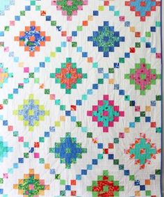 a colorful quilt is hanging on the wall