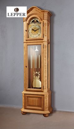 an old grandfather clock in the corner of a room with gray walls and concrete flooring