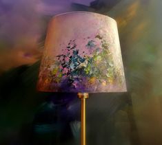 a lamp that is sitting on top of a wooden table next to a purple wall