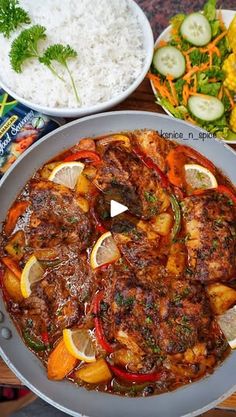 the meal is prepared and ready to be eaten on the table with rice, cucumbers, carrots, and other vegetables