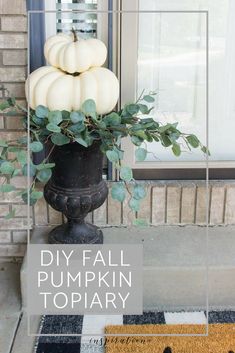 a black vase filled with white pumpkins sitting on top of a door sill