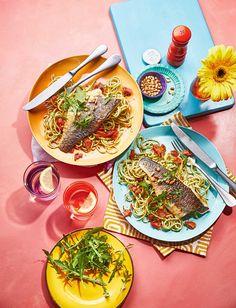 three plates of food on a pink table