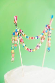 a white cake topped with colorful candy sticks