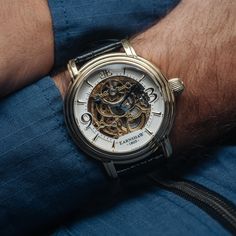 This three hand, automatic skeleton is a delightful aesthetic indulgence, with exposed mechanics and delicate yet lavish gems. Utter precision and care form the backbone of this timepiece. SPECIFICATIONS MOVEMENT: Automatic Skeleton 3 Hands with Open Heart CASE MATERIAL: Stainless Steel CASE DIAMETER (mm): 48 CASE THICKNESS (mm): 16 CASE COLOUR: Ionic Plating - Gold BAND: 22mm Black Genuine Leather Strap WATER RESISTANCE: 5 ATM WATCH WEIGHT (g): 100 Timeless Watch Accessories With Rotating Bezel, Luxury Skeleton Dial Watch For Anniversary, Elegant Silver Watch With Skeleton Dial, Elegant Automatic Watch Accessories For Gift, Elegant Skeleton Dial Watch Accessories For Formal Occasions, Elegant Formal Watch With Skeleton Dial, Steampunk Watches With Round Dial For Formal Occasions, Steampunk Automatic Watch For Formal Occasions, Classic Watches With Rotating Bezel As Gift