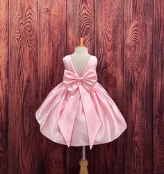 Our enchanting Knee Length flower girl dresses are sure to turn heads! This beautiful elegant sophisticated dress is handmade, the bodice consists of Pink Bridal Satin with a sowed in sash at the waist, the back of the dress consists of an open V-back with a zipper. The big bow is detachable. The skirt consists of pink satin followed by lining and crinoline for a fuller look. Extremely light weight and beautiful. This dress is perfect for any occasion!  Dress Is Pictured with a petticoat NOT INC Elegant Smash Cake, Pink Toddler Dress, Frocks For Kids, Junior Girl Dresses, Simple Frock Design, Wedding Flowers Summer, Wedding Flower Girl Dresses, Elegant Sophisticated, Pink Bridal