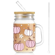 a glass jar filled with liquid next to a metal straw dispenser on a white background