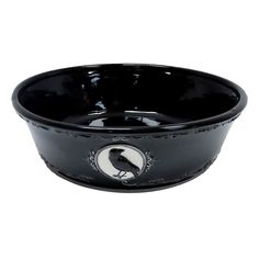 a black bowl with a bird on the side and a white circle in the middle