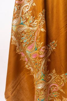 Wrap yourself in the warm embrace of autumn with this "Sozni Tilla Splendor Pashmina," a testament to timeless grace and artistry. Each thread of this luxurious pashmina has been tenderly hand-embroidered with the intricate sozni needlework, which dances along the fabric in harmonious golds and spirited pastels, reminiscent of Kashmir’s enchanting fall season. This pashmina is not merely an accessory; it is a piece of heritage, handcrafted with tilla, the golden touch that turns every drape into Pashmina Shawl Embroidery Hands, Sozni Embroidery, Gold Shawl, Embroidered Rug, Embroidered Handbag, Silk Carpet, Embroidered Wool, Pashmina Shawl, Embroidered Bag