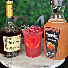 three different types of drinks on a table with one drink in the glass and another beverage in the bottle