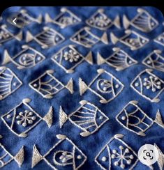 an embroidered blue cloth with silver designs on it