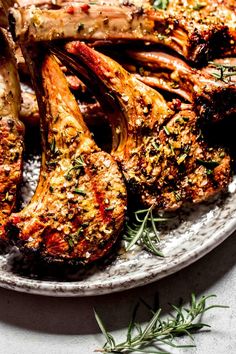 grilled chicken and vegetables on a plate with rosemary sprig garnish