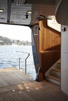 the inside of a boat with stairs leading up to it and water in the background