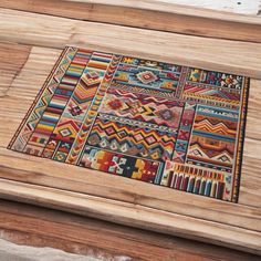 a wooden table with a multicolored rug on it's top and bottom