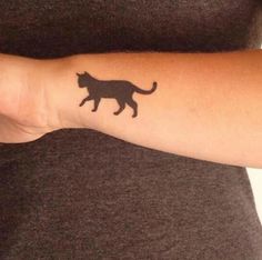 a woman with a cat tattoo on her arm and wrist is holding out her hand